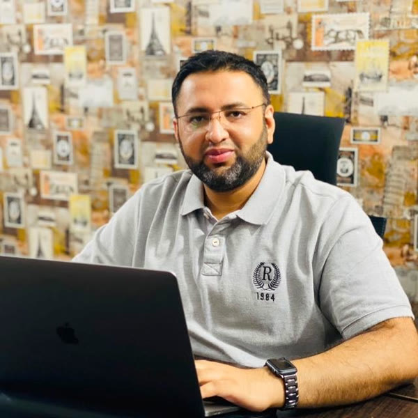 Rana Ahson, COO and Partner at EcomBack, at his desk working on a laptop.